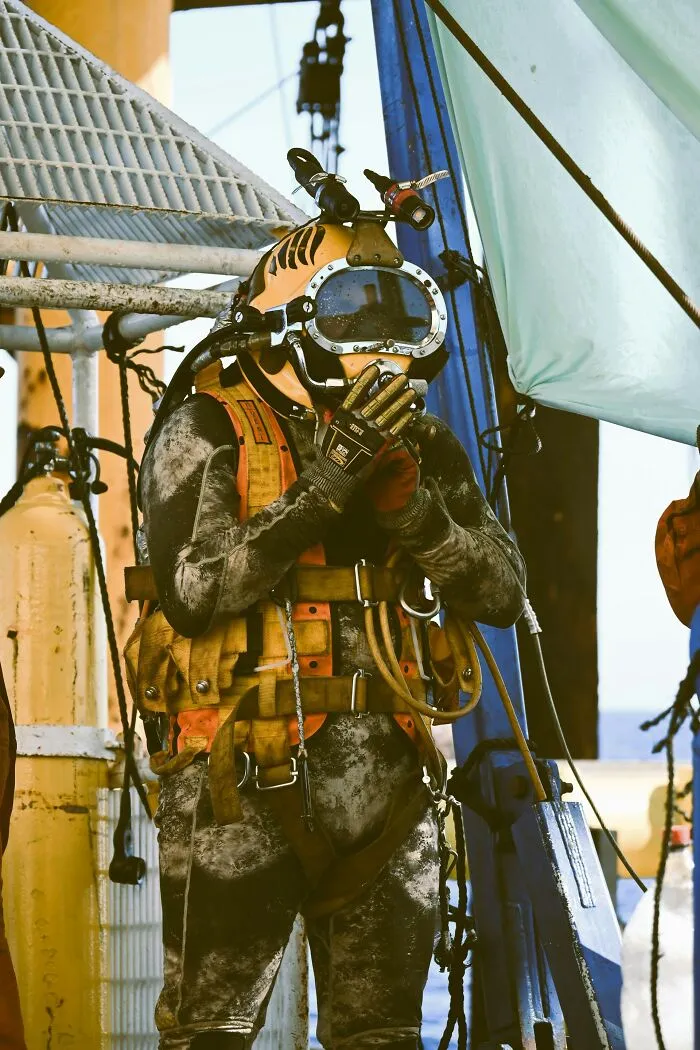 A fully equipped diver in a heavy yellow helmet and suit, highlighting disturbing death stories from the deep.