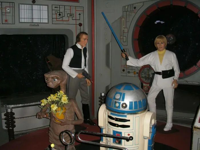 Celebrity wax figures including Star Wars characters posed in a sci-fi setting
