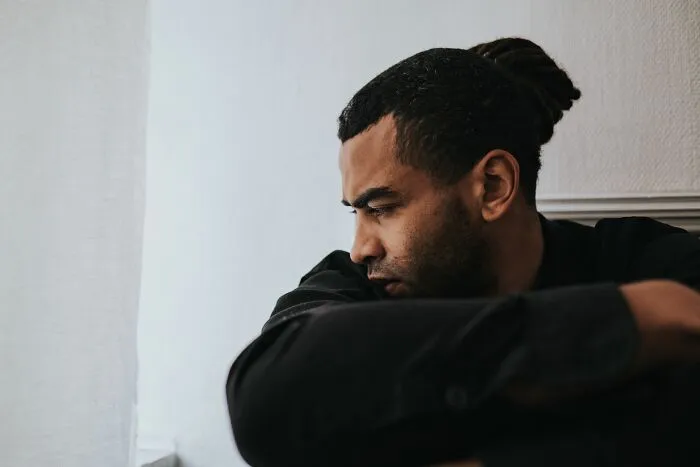 Man looking sad by the window lost in deep thought