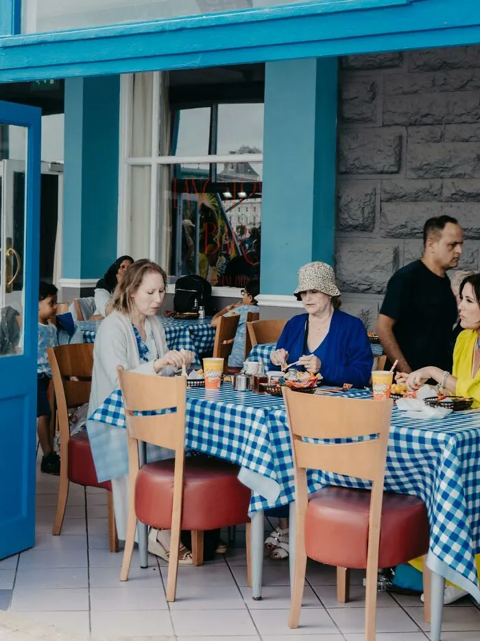 People sitting at a restaurant with blue checkered tablecloths