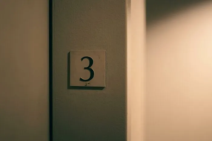 Door number three in dim light representing neighbors from hell apartment