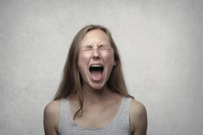 A young woman screaming in frustration, embodying wedding drama.