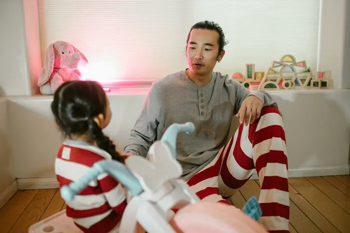 Father and child bonding indoors wearing casual clothes and playing together