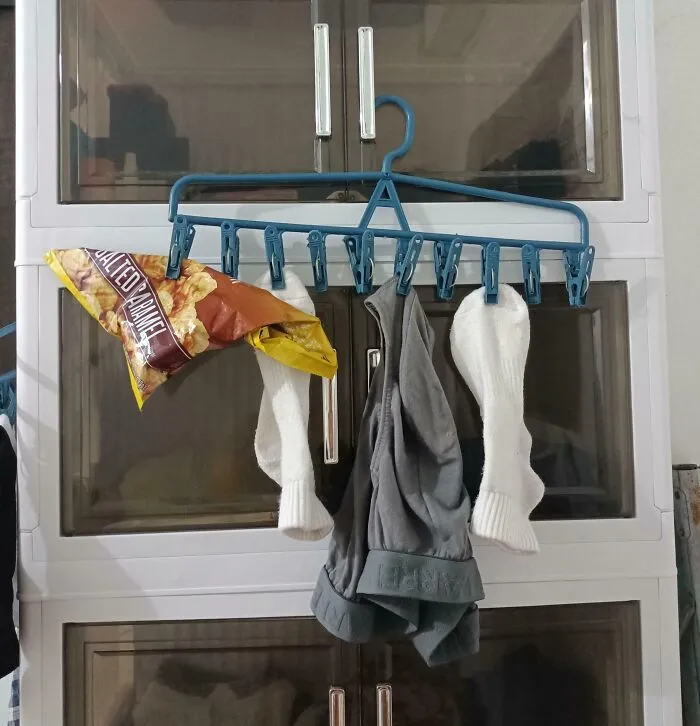 Clothes hanger holding socks, underwear, and a bag of snacks