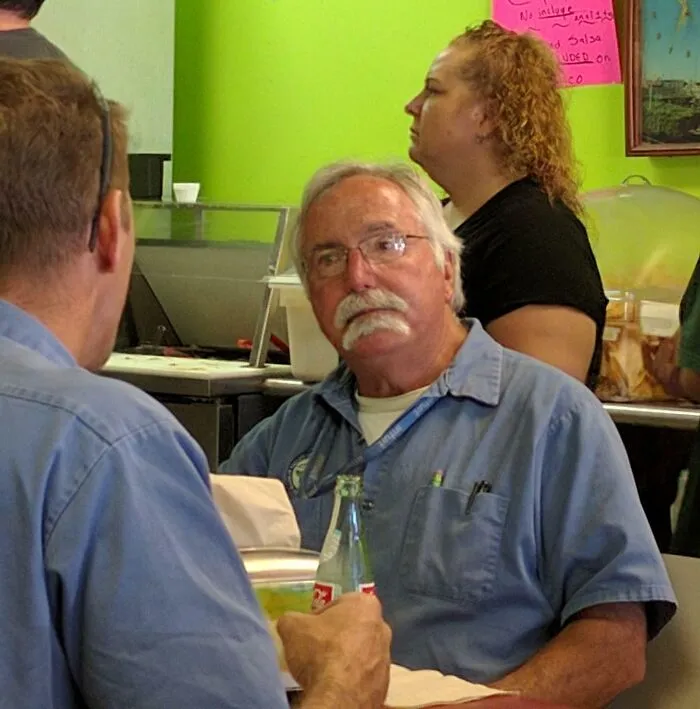 Funny candid photo of men sitting in casual setting