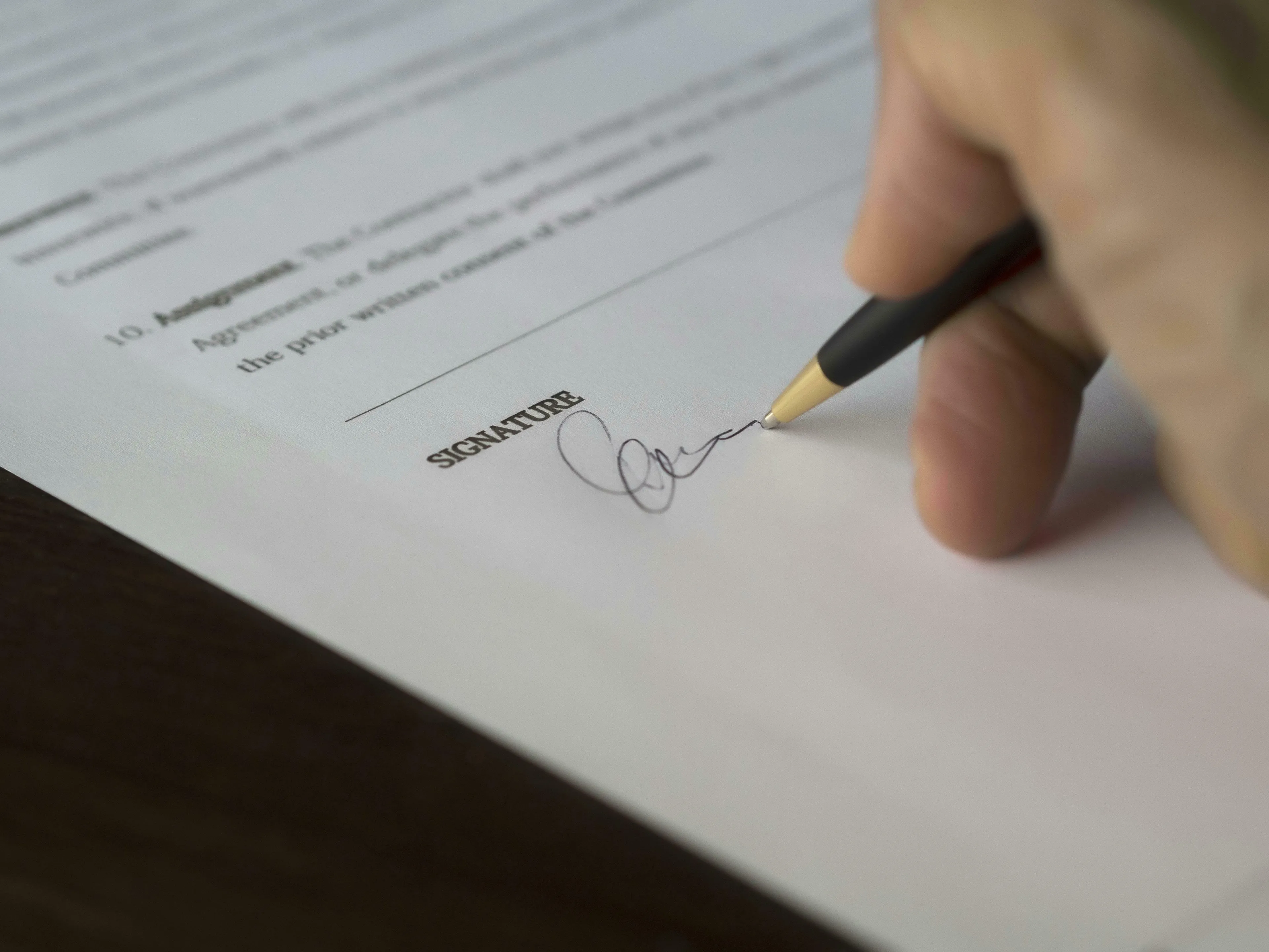 Hand signing a document under a "SIGNATURE" line. This represents European Union treaties and General Knowledge Quiz.