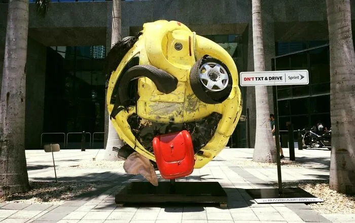 El artista local Rudolf Kohn transformó un coche destrozado en un emoji como anuncio de servicio público contra el uso del teléfono móvil al volante en Miami.