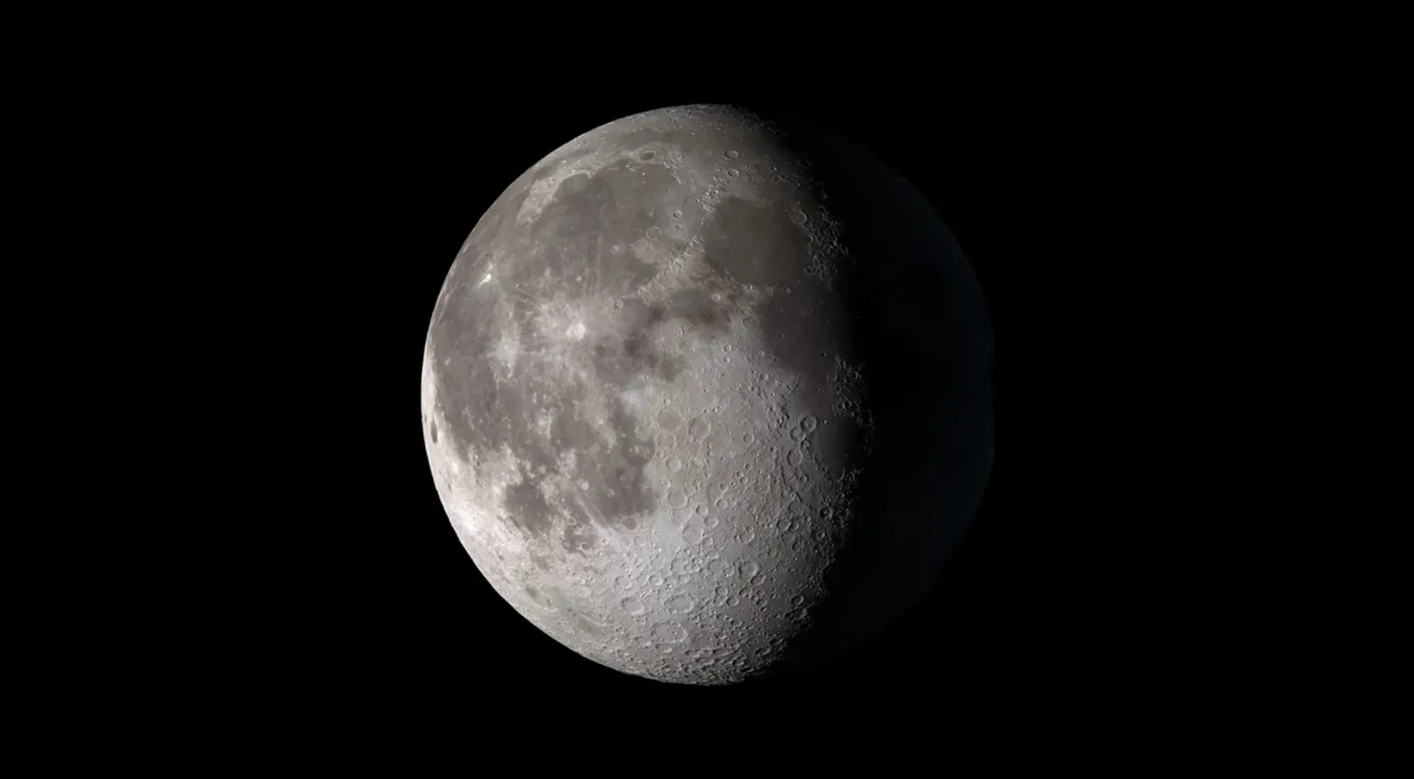Astronomy quiz: A dramatic shot of the Moon, half illuminated against the blackness of space, showcasing its many craters. Moon phase.