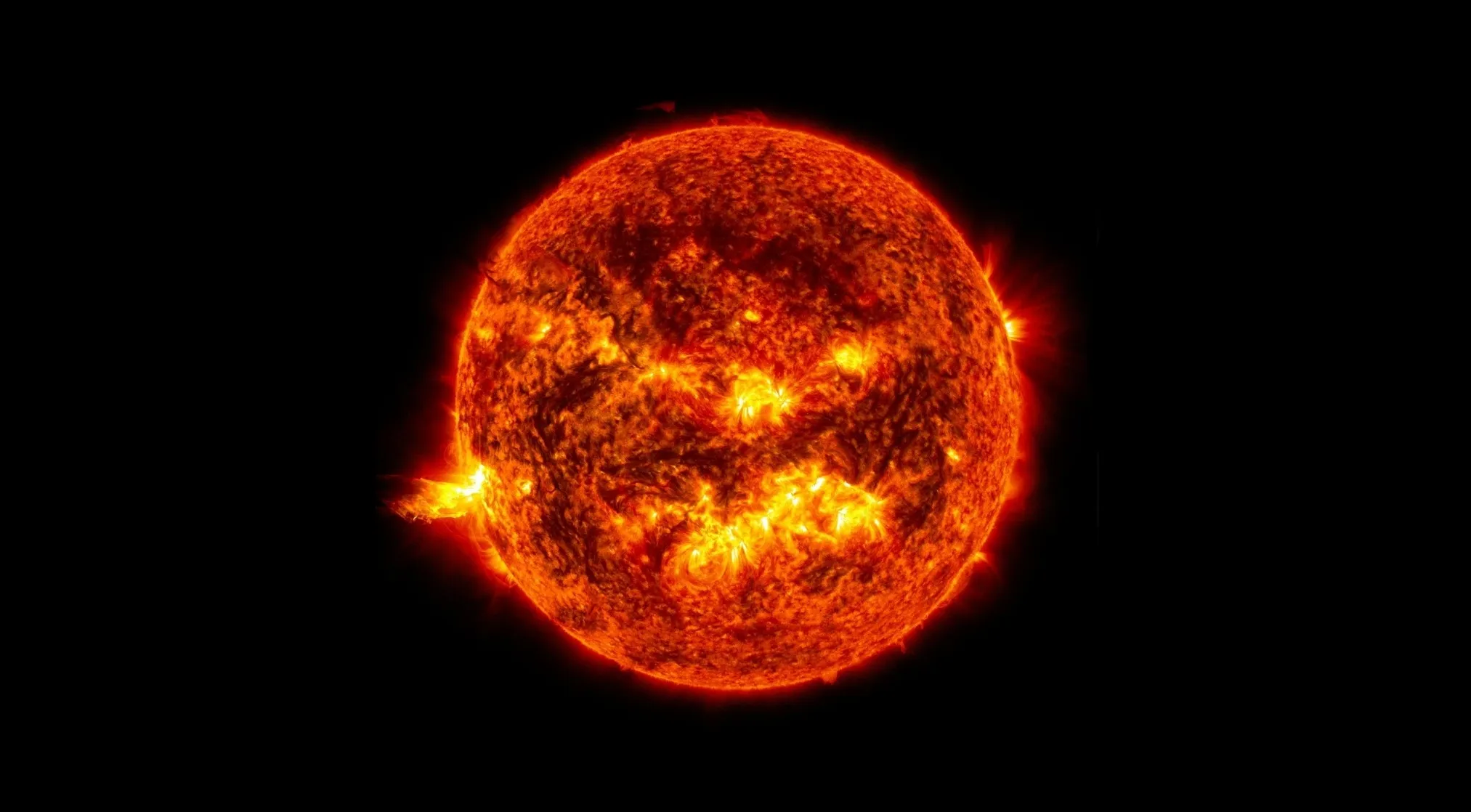 A vibrant, fiery image of the Sun with solar flares visible, set against a dark background. Astronomy quiz: main component of the Sun.