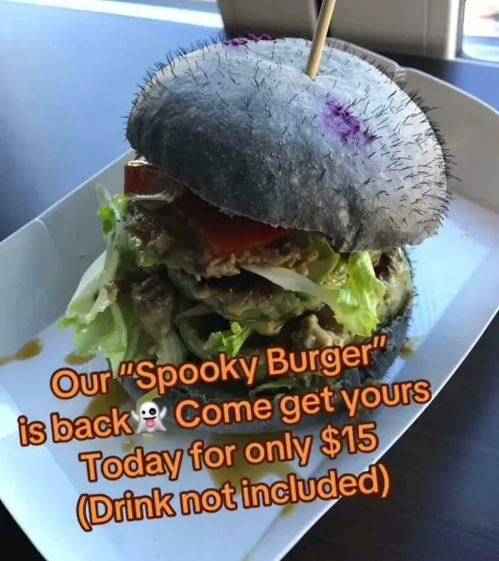 Spooky burger with black bun and Halloween promotion sign