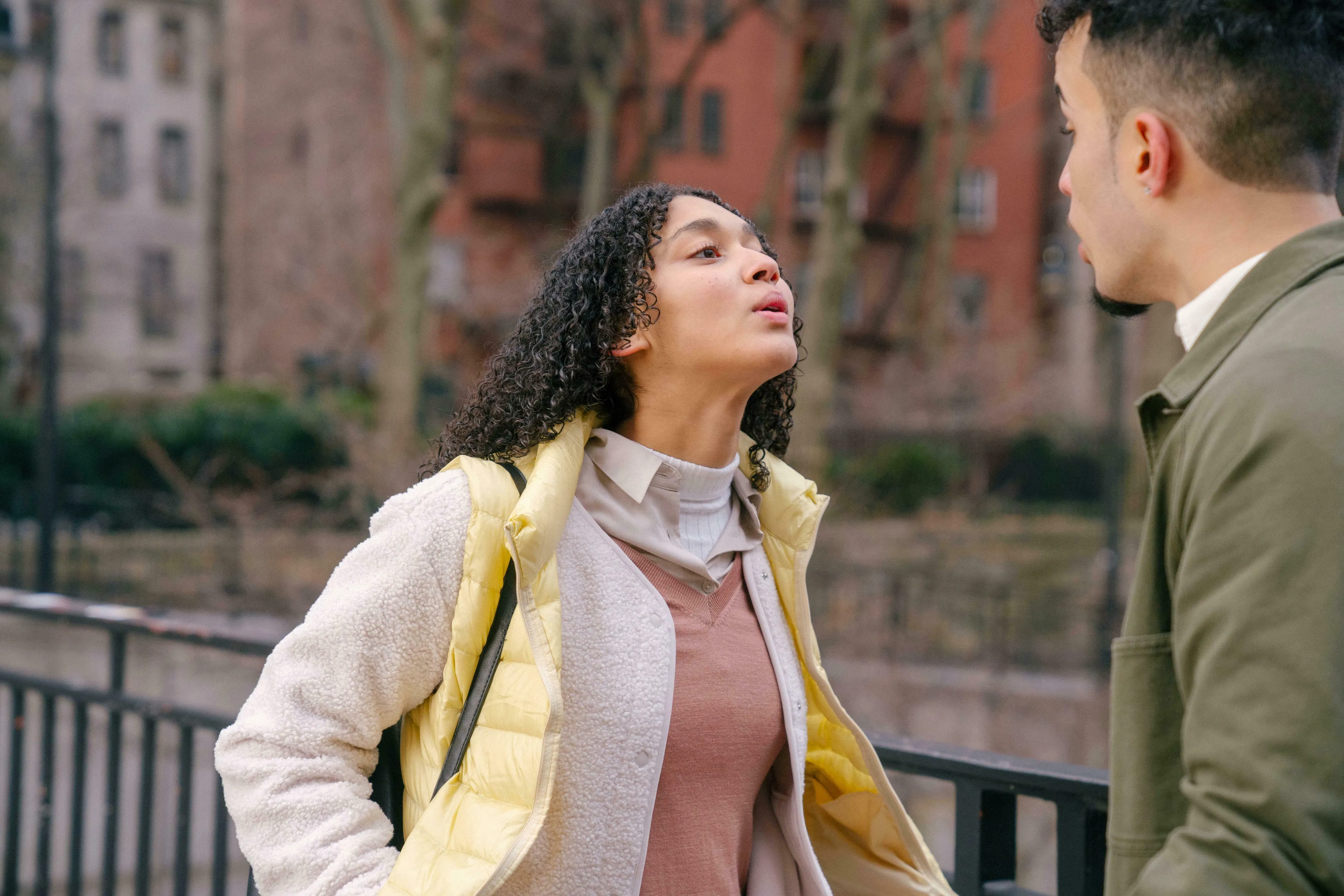 A young woman with curly hair looks up and to the right, talking to a man. Exploring how to handle being wrong.