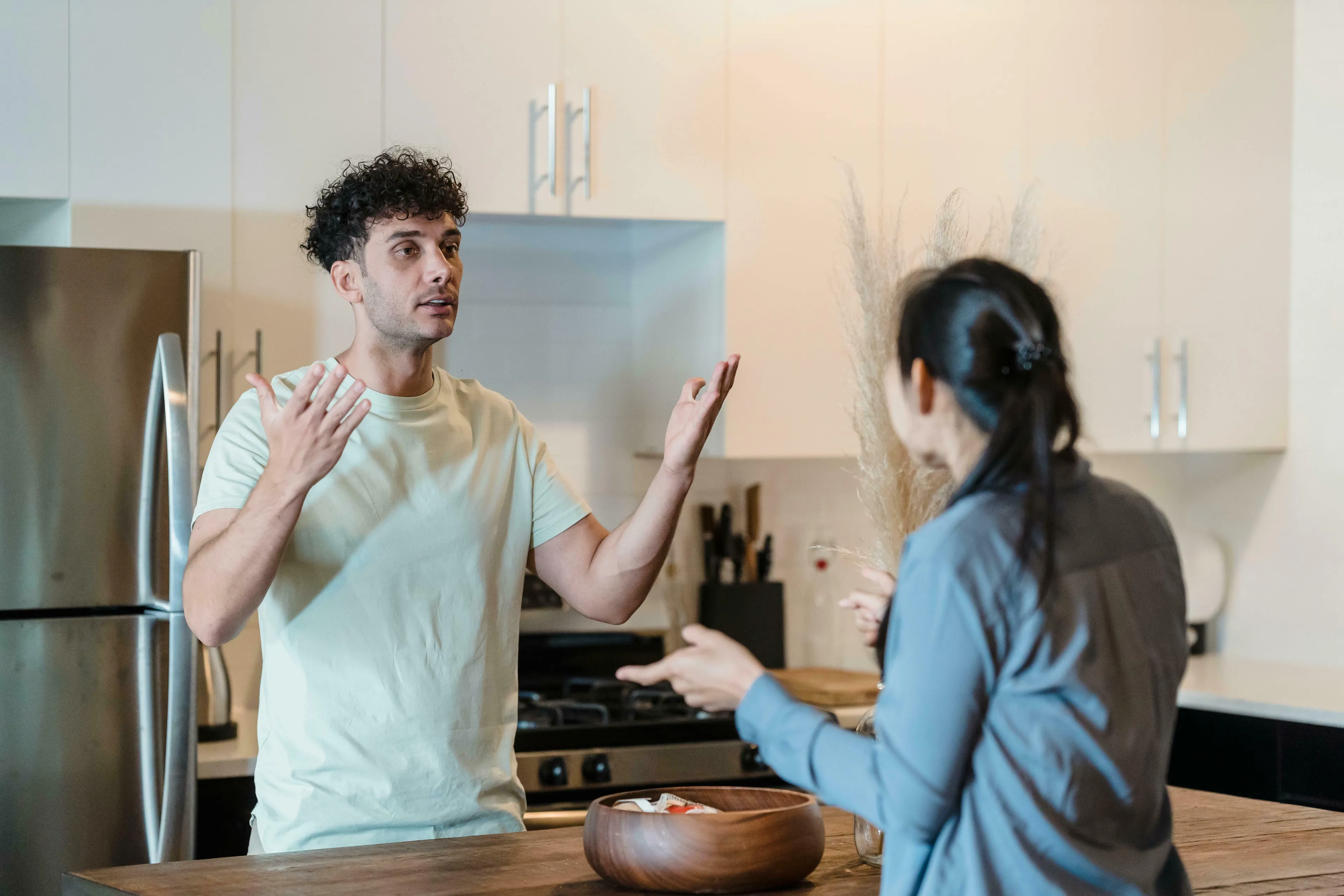 A man explaining something in a kitchen to a woman. Dealing with being wrong can be a challenge.