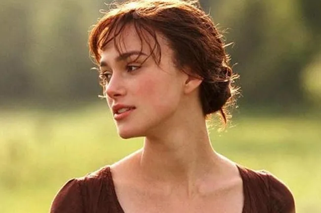 Elizabeth Bennet, a fictional character, portrayed by a woman with brown hair in a natural outdoor setting.