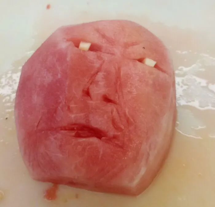 Watermelon carved to look like an angry face with teeth