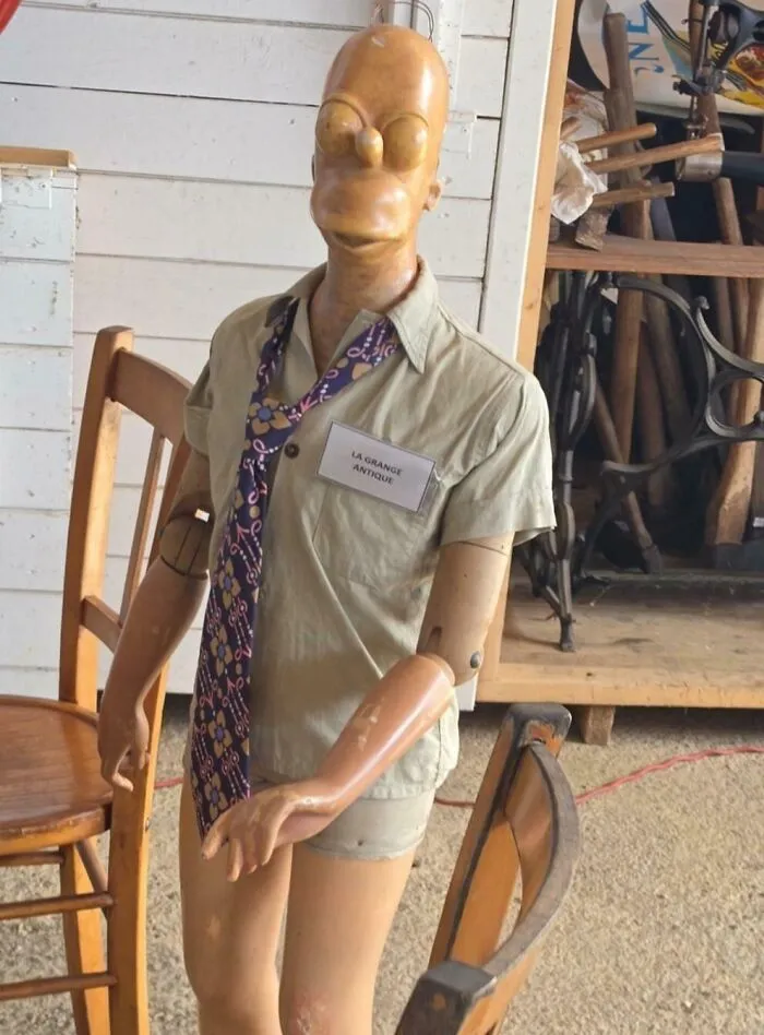 Wooden mannequin head resembling Homer Simpson in antique store