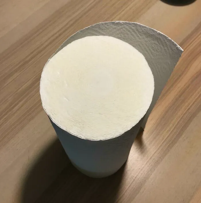 Close-up of a large roll of textured paper towels on a wooden surface