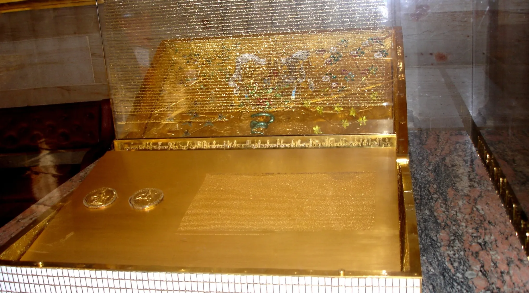 A gold display case with the Magna Carta inside, shown under protective glass. Pub Quiz related historical item.