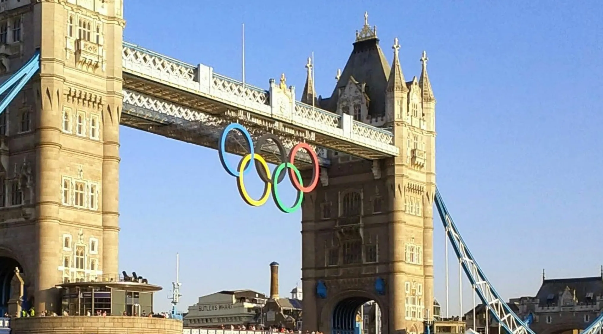 Pub Quiz image: The Tower Bridge in London with Olympic rings hanging from it, clear blue sky.