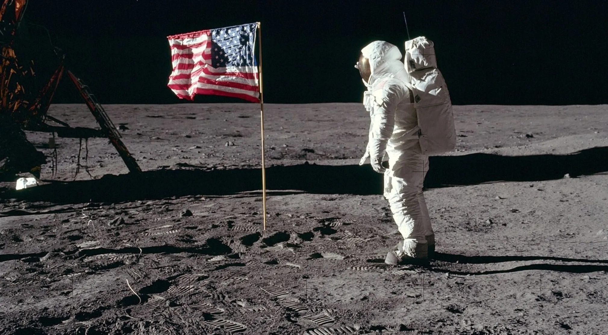 Astronaut in a spacesuit on the moon next to the US flag and lunar lander, highlighting USA Throughout History.
