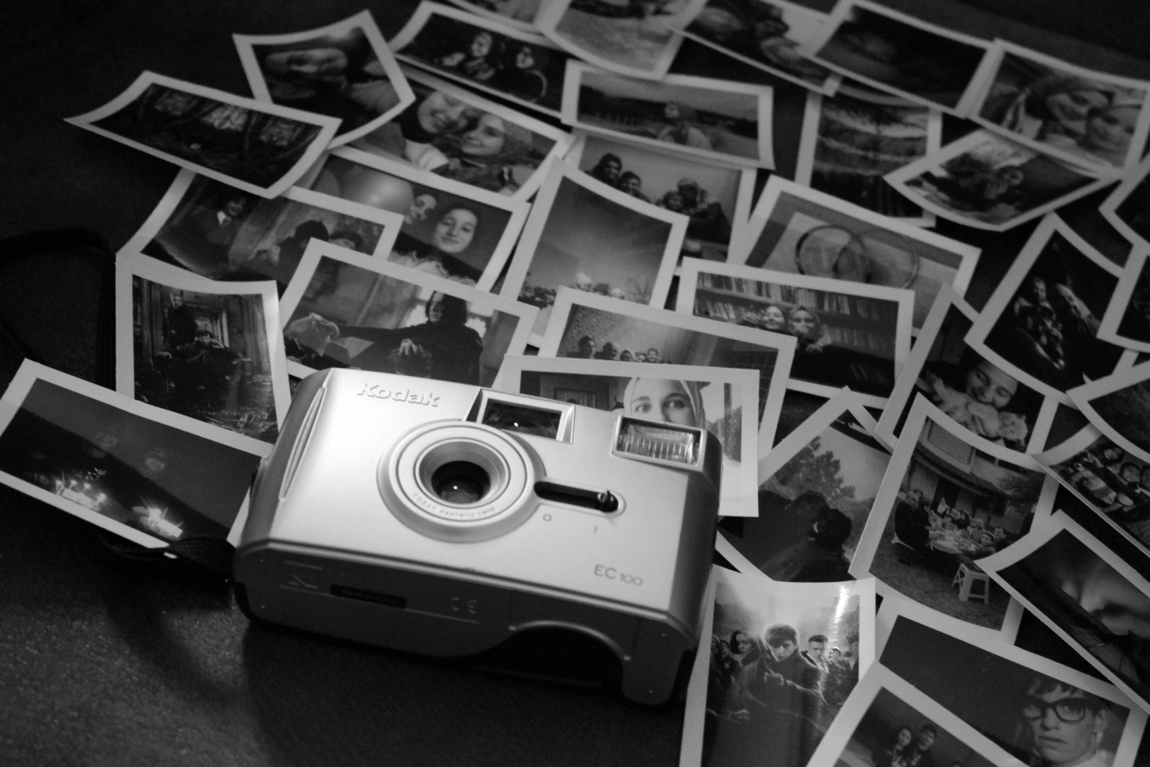 A Kodak camera surrounded by scattered black and white photos, evoking nostalgia and reflecting true nature.