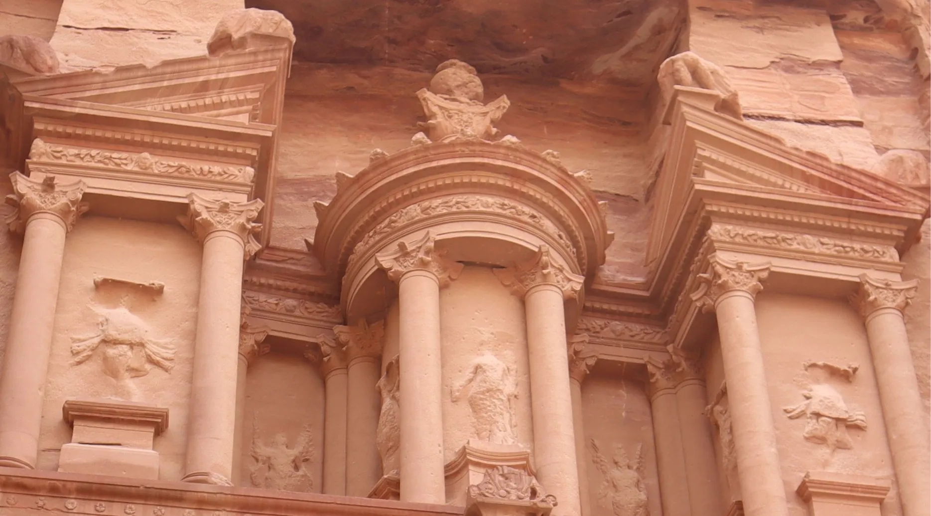 Zoomed-in photo of Petra's ornate sandstone carvings. Guess the landmark from this zoomed-in image of the ancient facade.