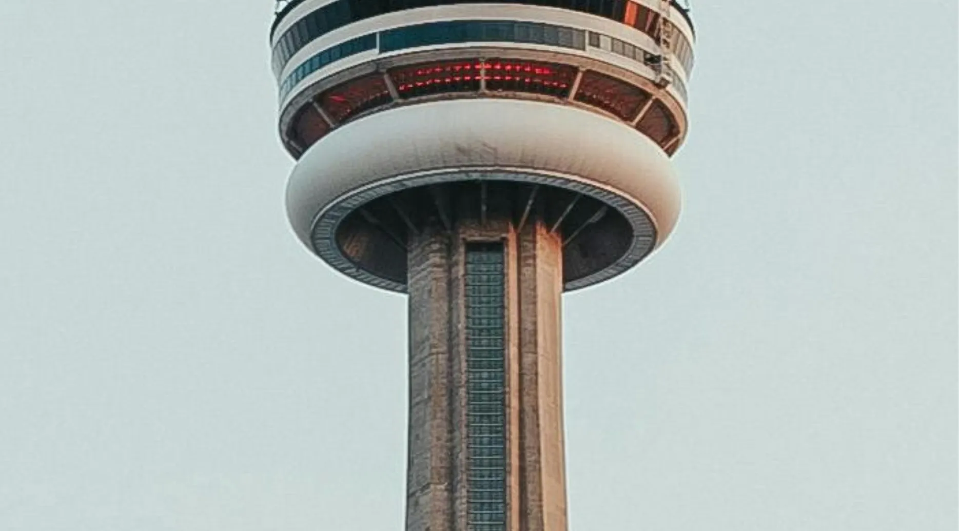A zoomed-in image of the CN Tower's observation deck against a clear sky. Guess the landmark from this photo!