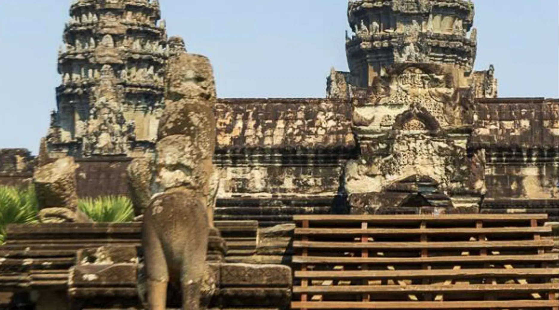 Identify the landmark: a zoomed-in photo of an ancient, ornate stone temple with intricate carvings and statues.