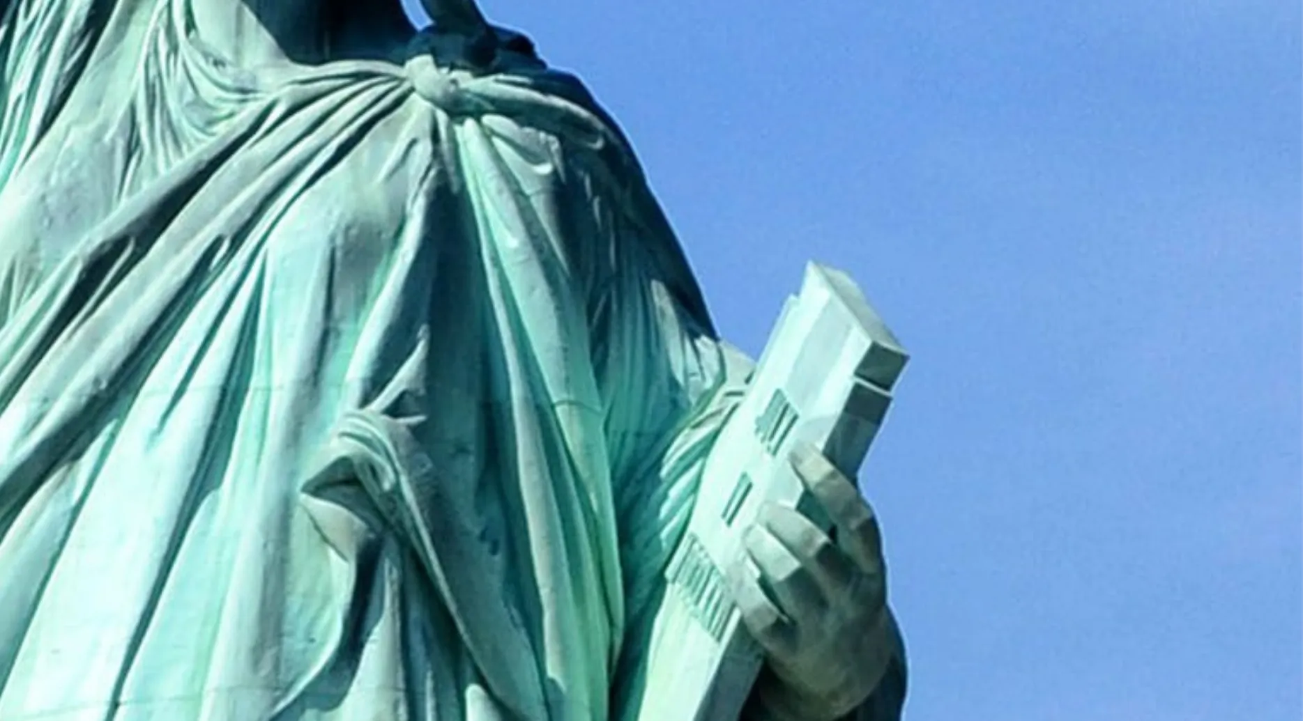 Close-up of the Statue of Liberty's arm holding a tablet. Guess the landmark from the zoomed-in image.