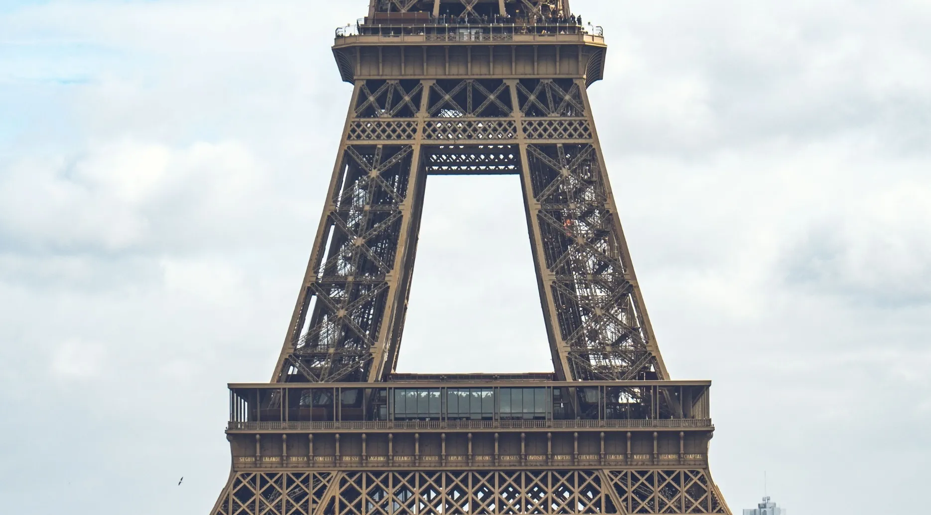 Name the landmark in this zoomed-in photo: A close-up view of the Eiffel Tower's intricate iron lattice structure.