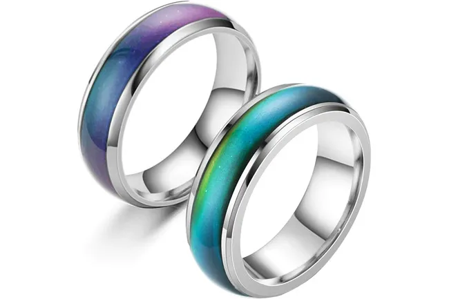 Two mood rings with silver bands, one showing purple and blue hues, the other green and teal.