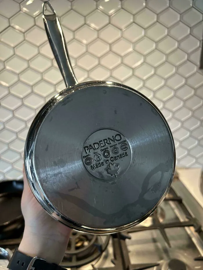 Hand holding a durable Paderno stainless steel pot, showing old products that refuse to give up.