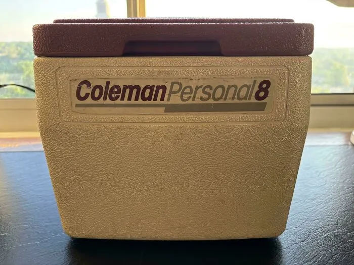 A beige and red Coleman Personal 8 cooler, representing vintage old products that remain functional after decades.
