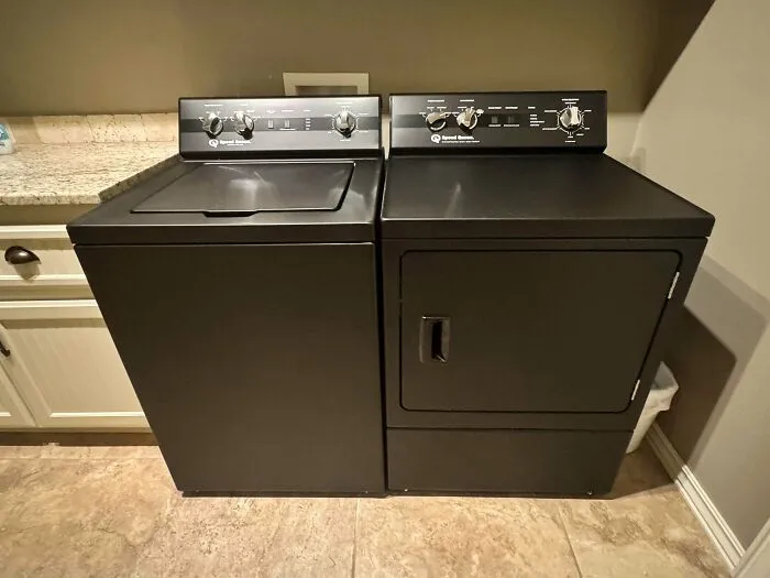 A black Speed Queen washer and dryer set, illustrating reliable old products designed for long-term daily use.