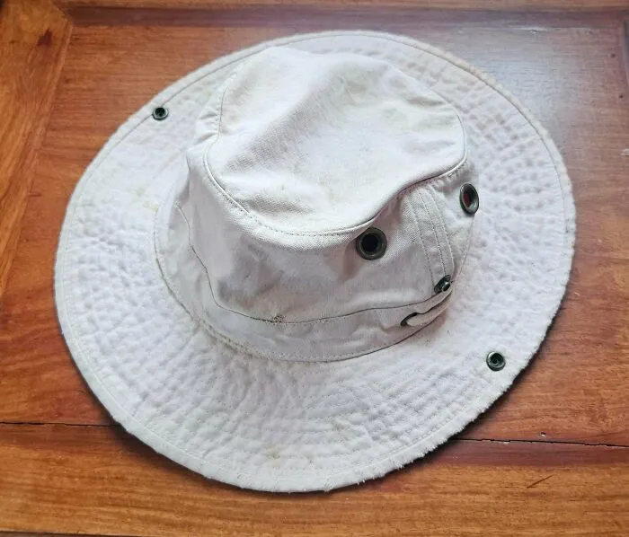 Light beige safari hat resting on a wooden surface, showcasing old products built to endure daily use over decades.