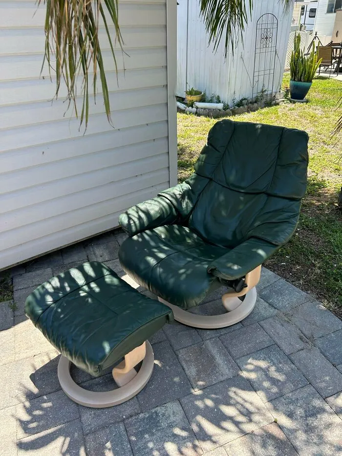 A green leather Stressless recliner and ottoman outdoors, an example of durable old products.