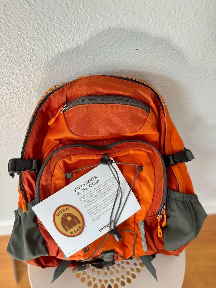 An orange Patagonia backpack with a Worn Wear note on it, illustrating old products that refuse to give up