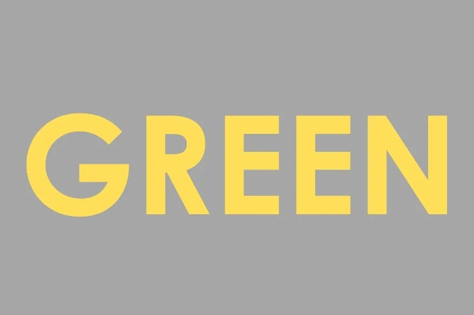The word GREEN spelled in the color yellow on a gray background, challenging perception of the color yellow.