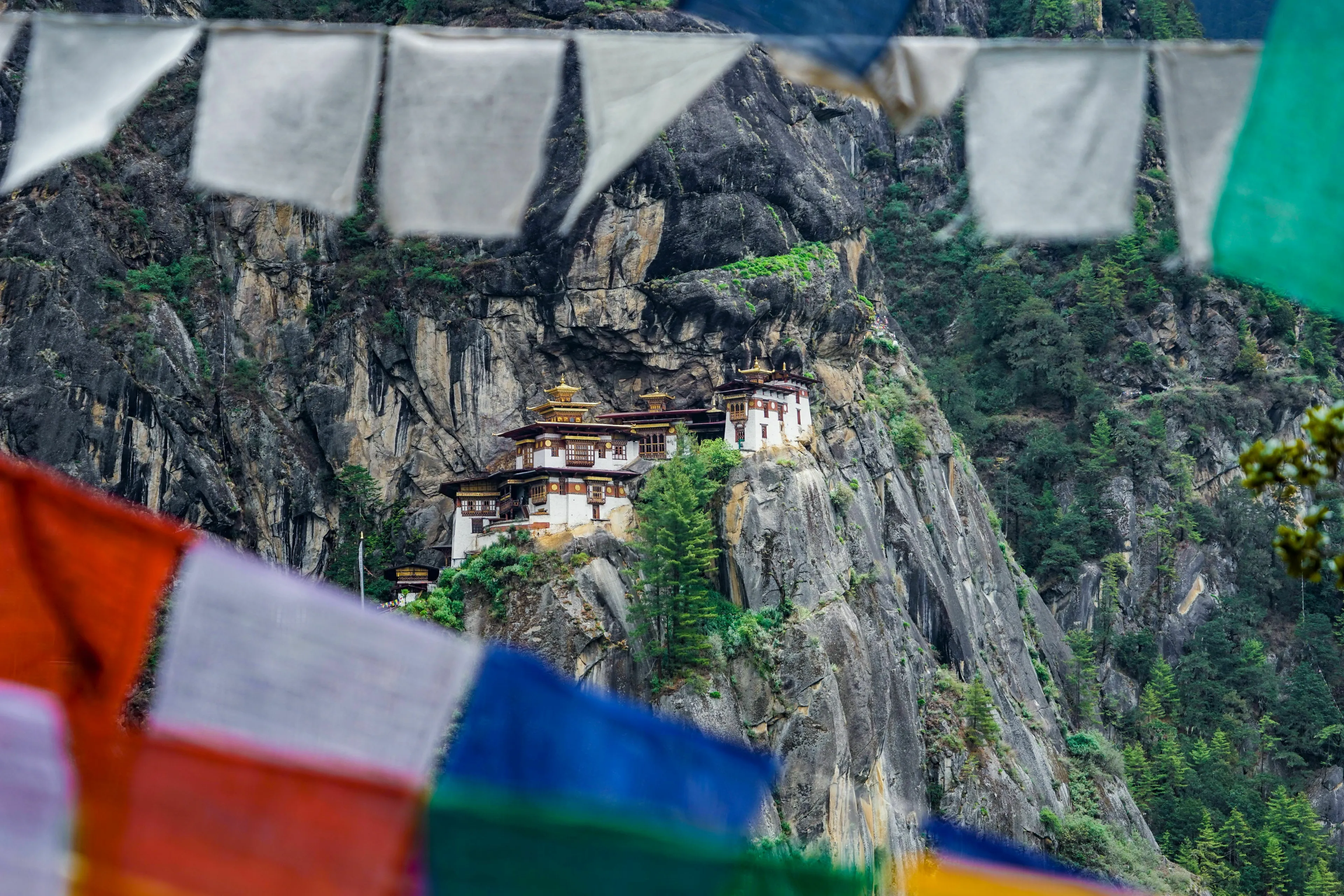 Prayer flags frame the iconic Tiger's Nest Monastery, perched dramatically on a cliffside in Bhutan. General knowledge quiz.