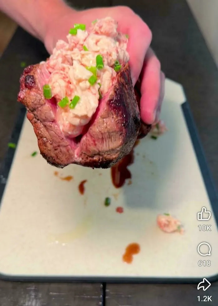 Steak stuffed with seafood salad and chives, strange food combo served on a plate