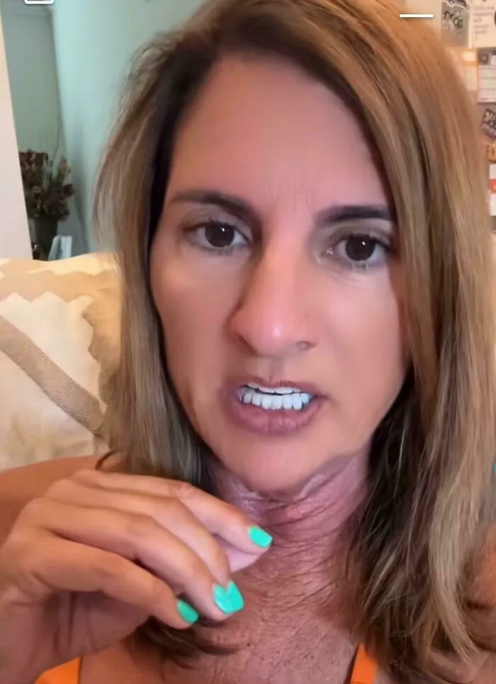 Close up of a woman speaking on camera showing the contrast between smooth face filters and neck aging in Instagram Reality.