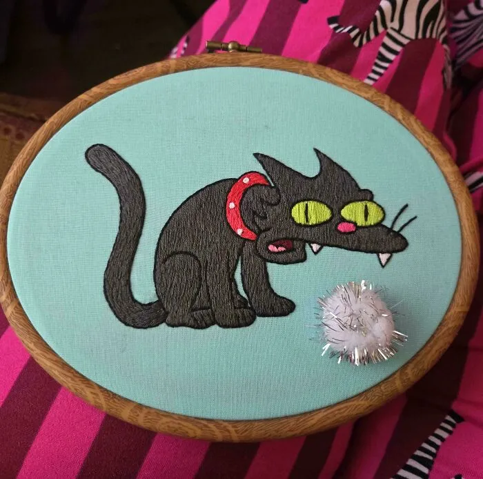 Cartoon cat Snowball II embroidery project in a wooden hoop