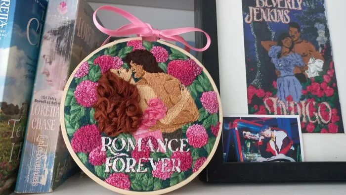 Romance novel cover style embroidery project with flowers and a couple