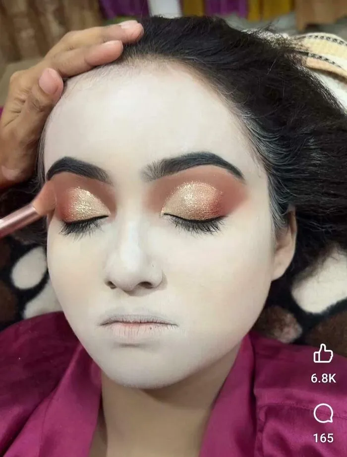 A person receiving a beauty salon treatment for dramatic eye makeup, looking significantly worse than expected.