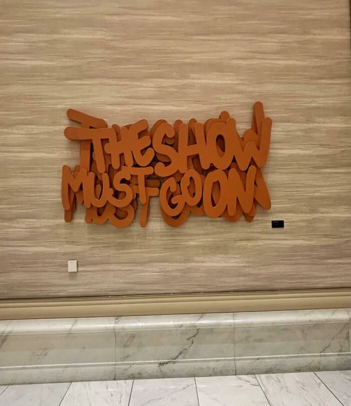 Wall text the show must go on with overlapping letters design fail