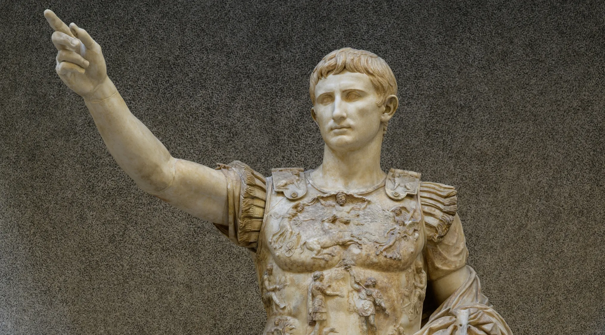 Marble statue of Augustus, the first emperor of the Roman Empire, wearing an ornate cuirass and pointing.