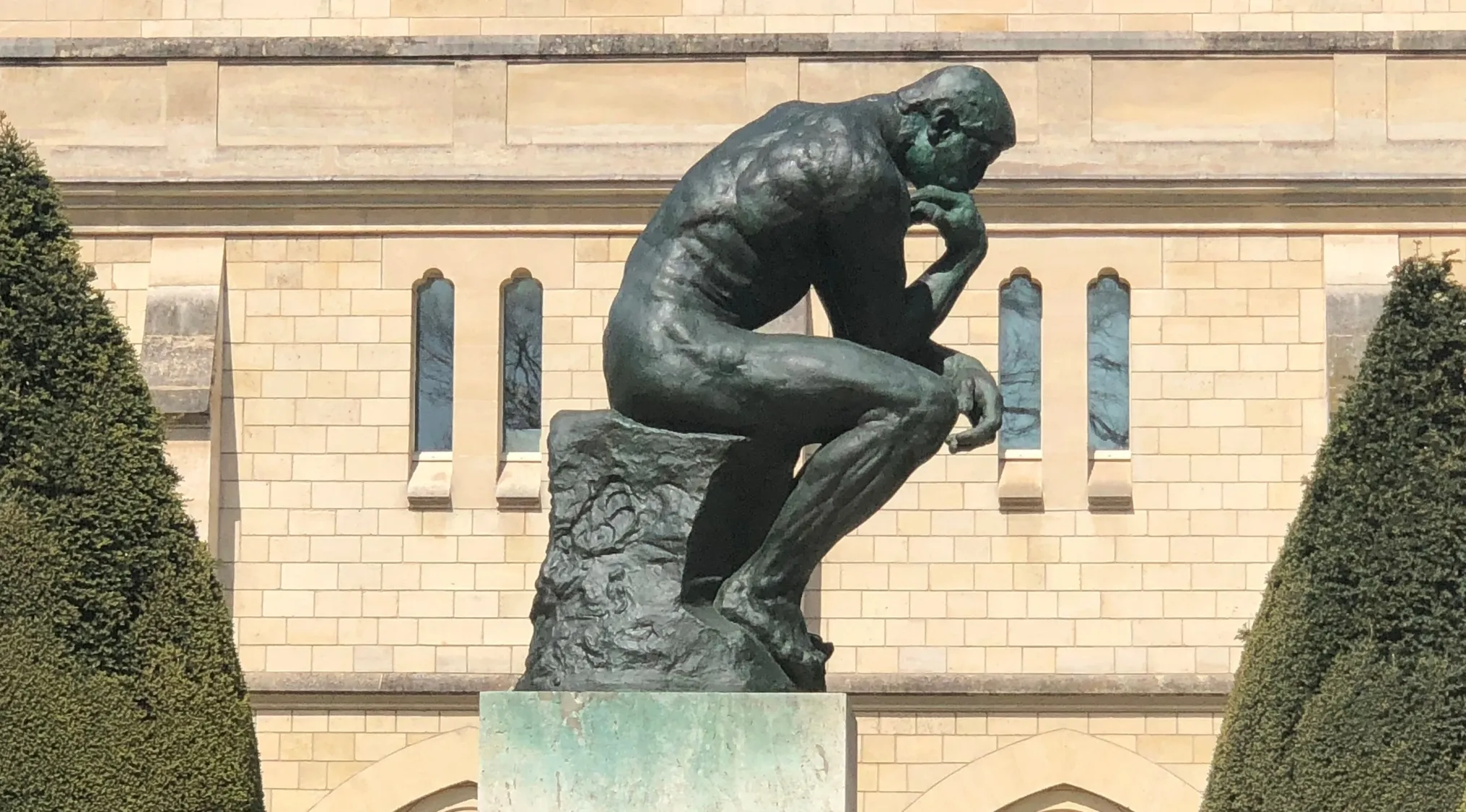 Rodin's The Thinker statue, a bronze figure contemplating, illustrating the human knowledge branch of philosophy.