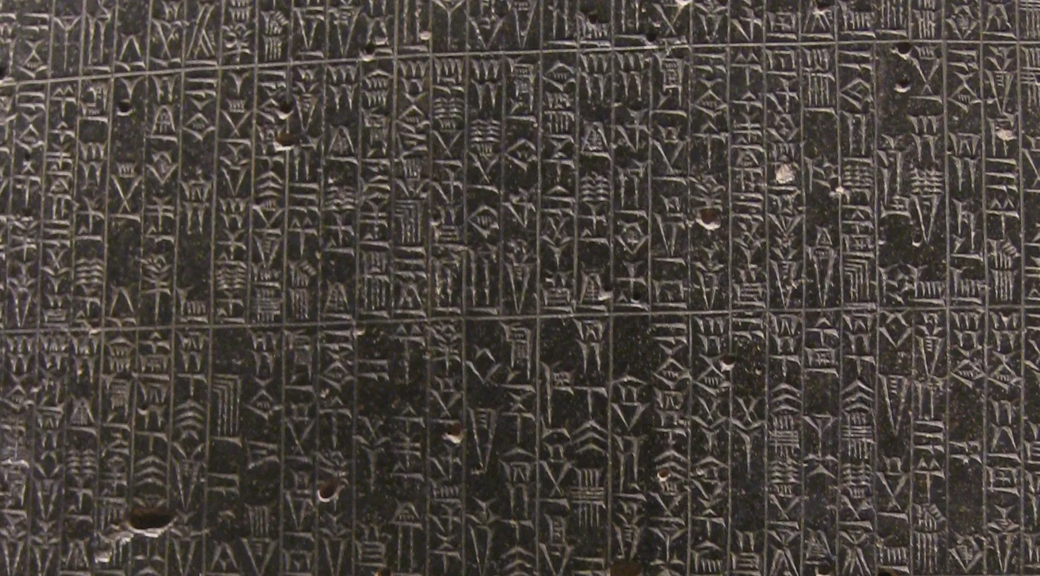Close-up of ancient legal code, a dark stone tablet covered in intricate cuneiform writing, referencing the law of retaliation.
