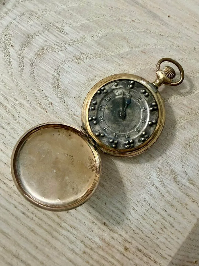 Open pocket watch showing raised braille dots on dial as an antique treasure