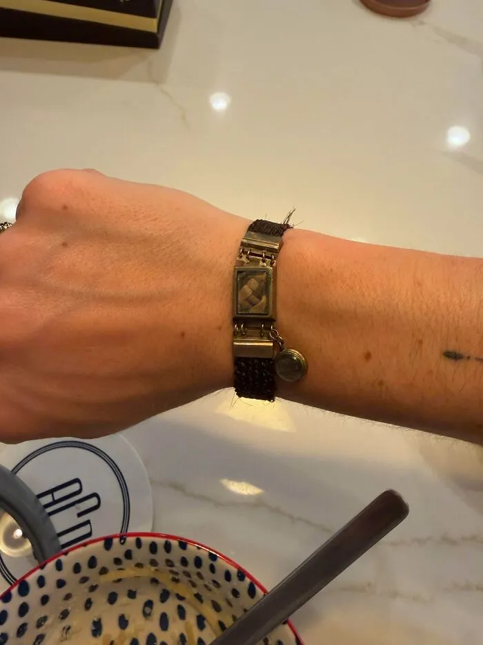 Hand wearing a woven hair memorial bracelet, an example of old treasures and unique finds for antique lovers.