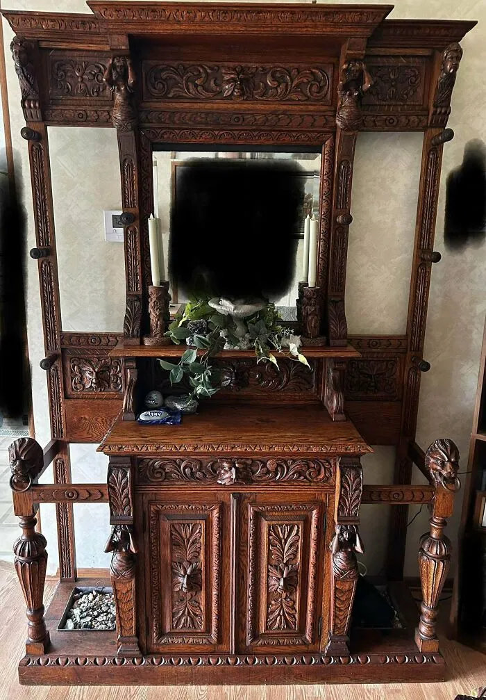 An intricately carved vintage wooden hall tree with a mirror, a classic find for antique lovers.